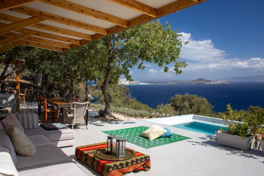 een villa met een zwembad en uitzicht op de oceaan bij My Old Stone House in a 2 000 sqm private garden with Fab Glamping Tent in Mandrákion