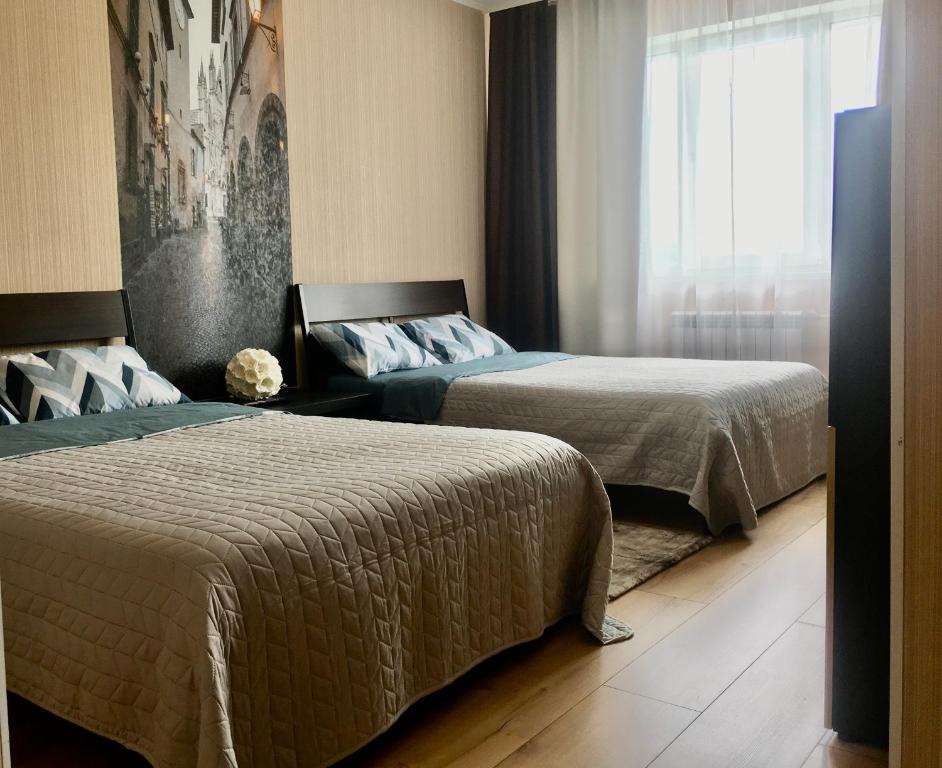 - une chambre avec 2 lits et une fenêtre dans l'établissement Apartments at metro Krasniy prospekt - Pokryshkina, à Novossibirsk