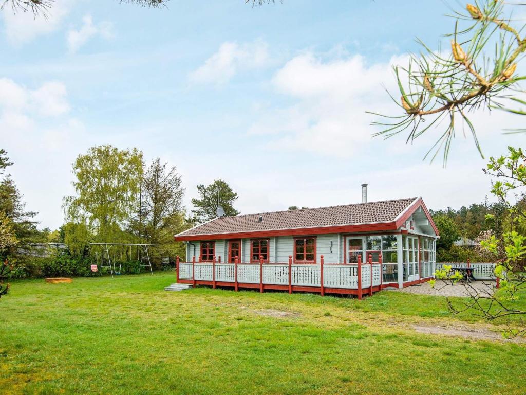 エーベルトフトにある6 person holiday home in Ebeltoftの広い庭のある赤と白の家