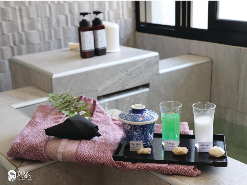 a tray with a bottle of milk and two glasses at Tree Tara hotel in Lampang