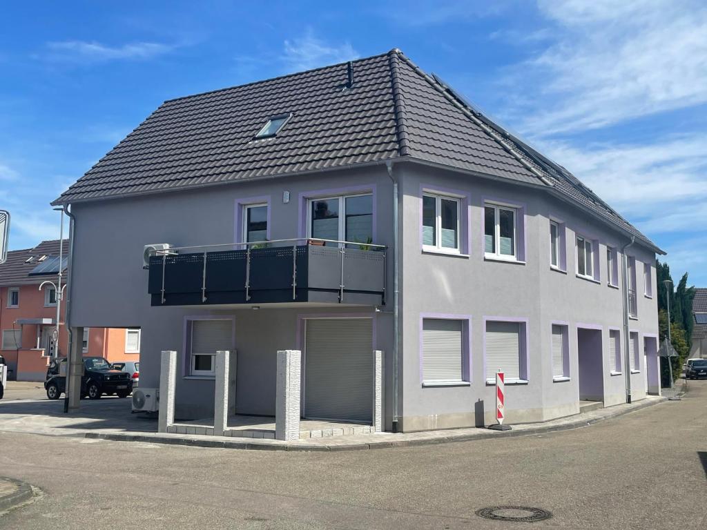 a large gray house with a balcony on a street at Im Unterdorf Apartments Rust in Rust