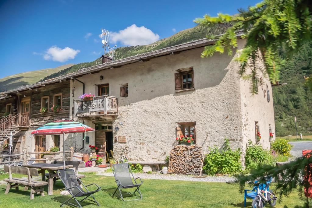 a house with a table and chairs in front of it at Bed & Breakfast Campaciol in Livigno