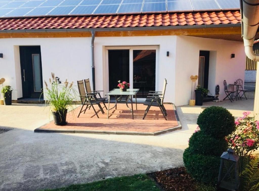 eine Terrasse mit einem Tisch und Stühlen vor einem Haus in der Unterkunft Ferienscheune Maria in Lichtenfels