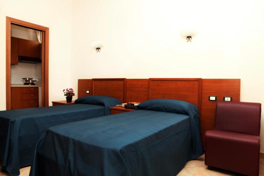 two beds with blue sheets in a room at Residence Hotel Gloria in Palermo
