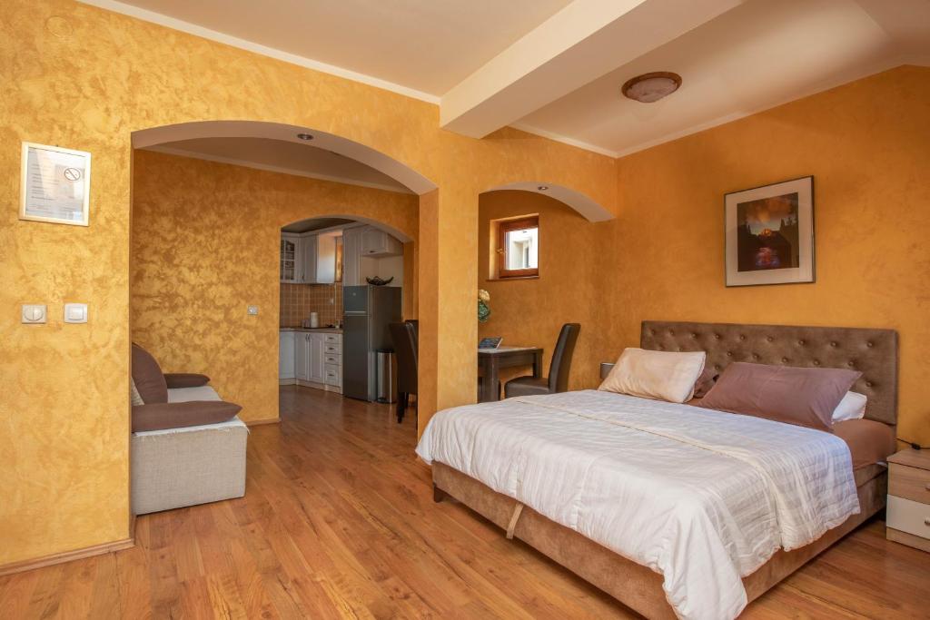 a bedroom with a bed and a living room at Apartments Nikčević in Kotor