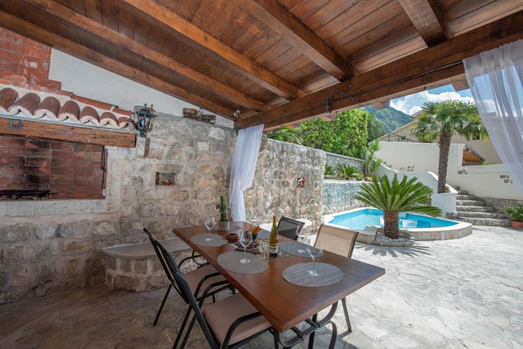 a patio with a table and chairs and a pool at Apartments Nikčević in Kotor