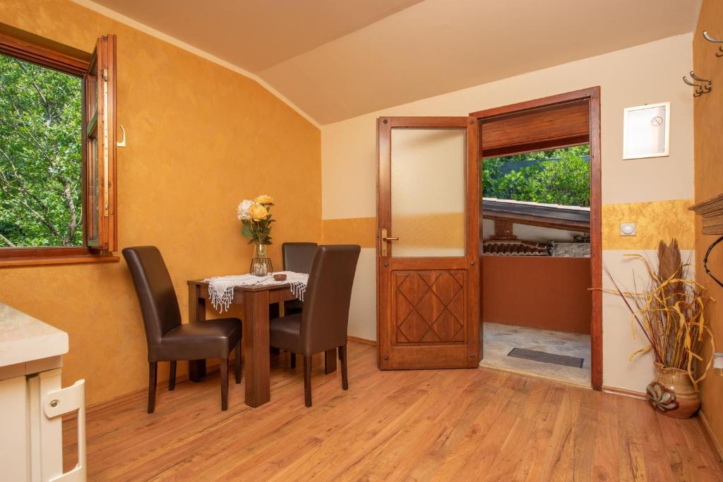 a dining room with a table and chairs and a door at Apartments Nikčević in Kotor
