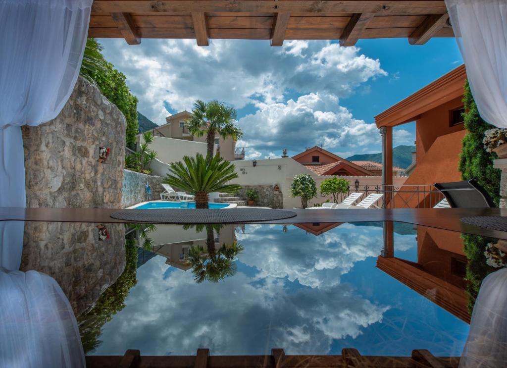 a pool with a reflection of the sky in the water at Apartments Nikčević in Kotor
