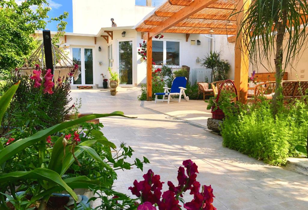 un patio con fiori e una sedia in una casa di B&B IreneMarchese Gluten Free a Taviano
