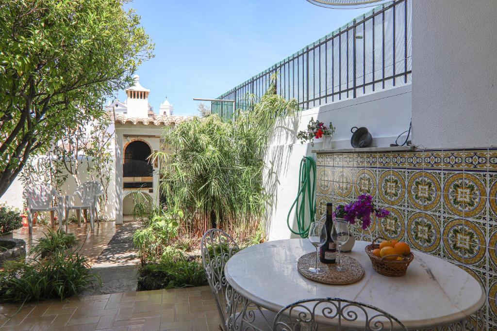 a table with a bowl of fruit on a patio at Casa Tangerina in Tavira