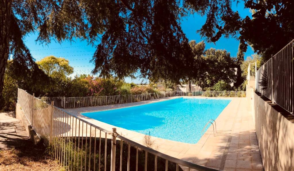 een zwembad in een tuin met een hek bij Sun7 view Montpellier, Piscine, Parking GRATUIT in Grabels