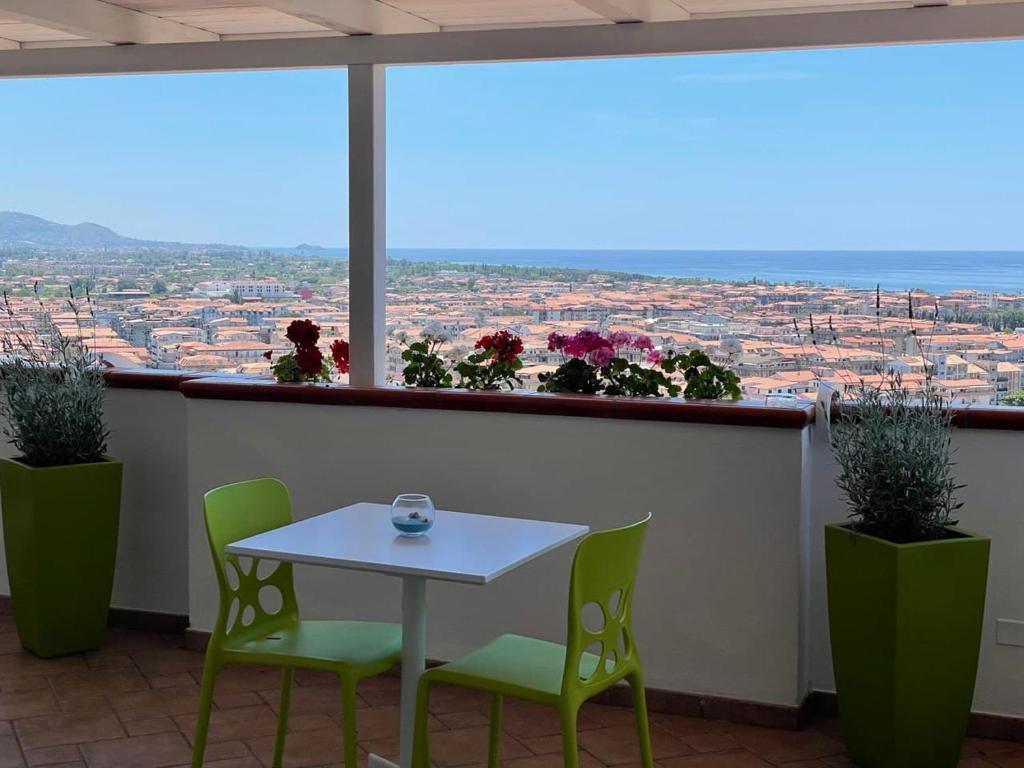 una mesa y sillas en un balcón con vistas en Il Belvedere Guest House, en Scalea