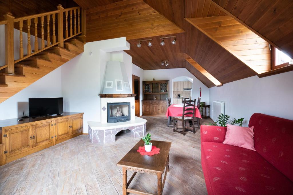 sala de estar con sofá rojo y chimenea en Holiday apartment Pika, en Bovec