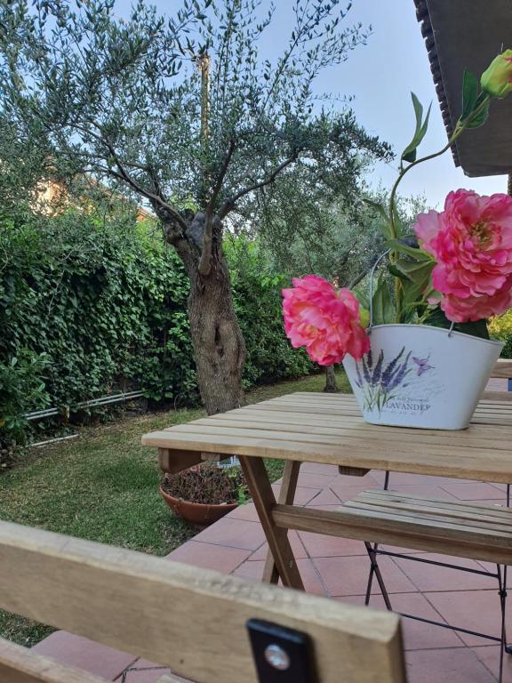 einen Picknicktisch mit rosa Blumen in einem Topf darauf in der Unterkunft Villa Martina in Mascalucia