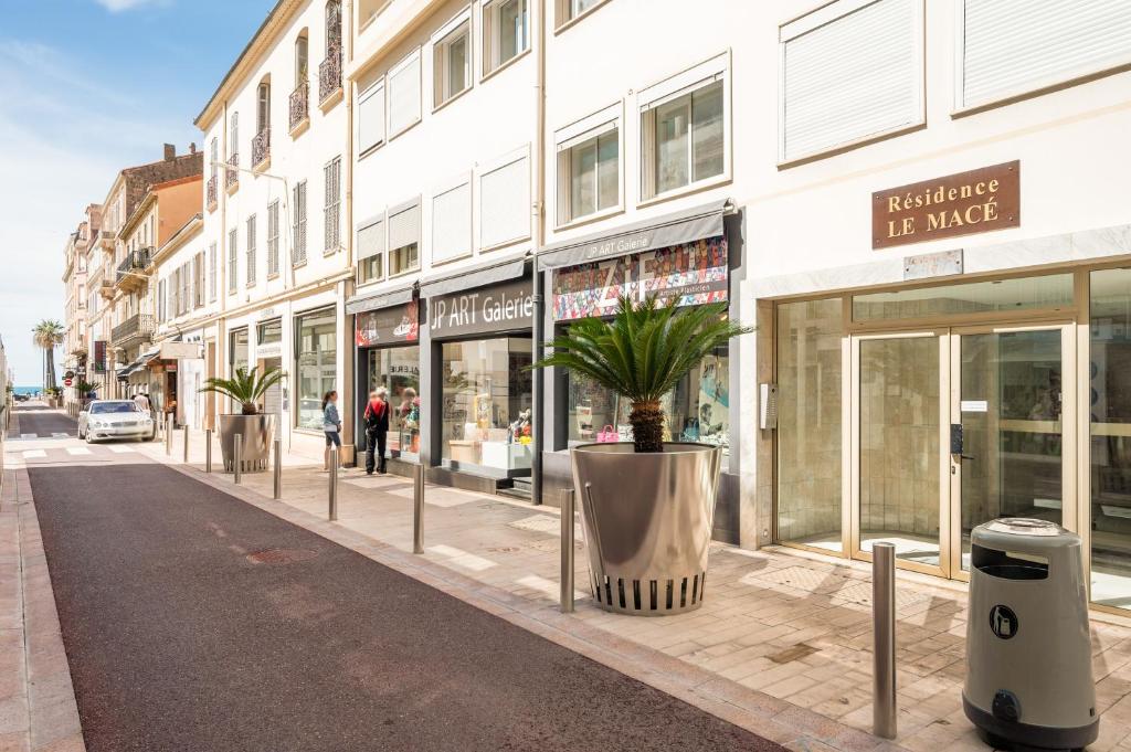 une rue de la ville avec une usine de pot sur le trottoir dans l'établissement Superbes studios entièrement rénovés - 50m croisette, à Cannes