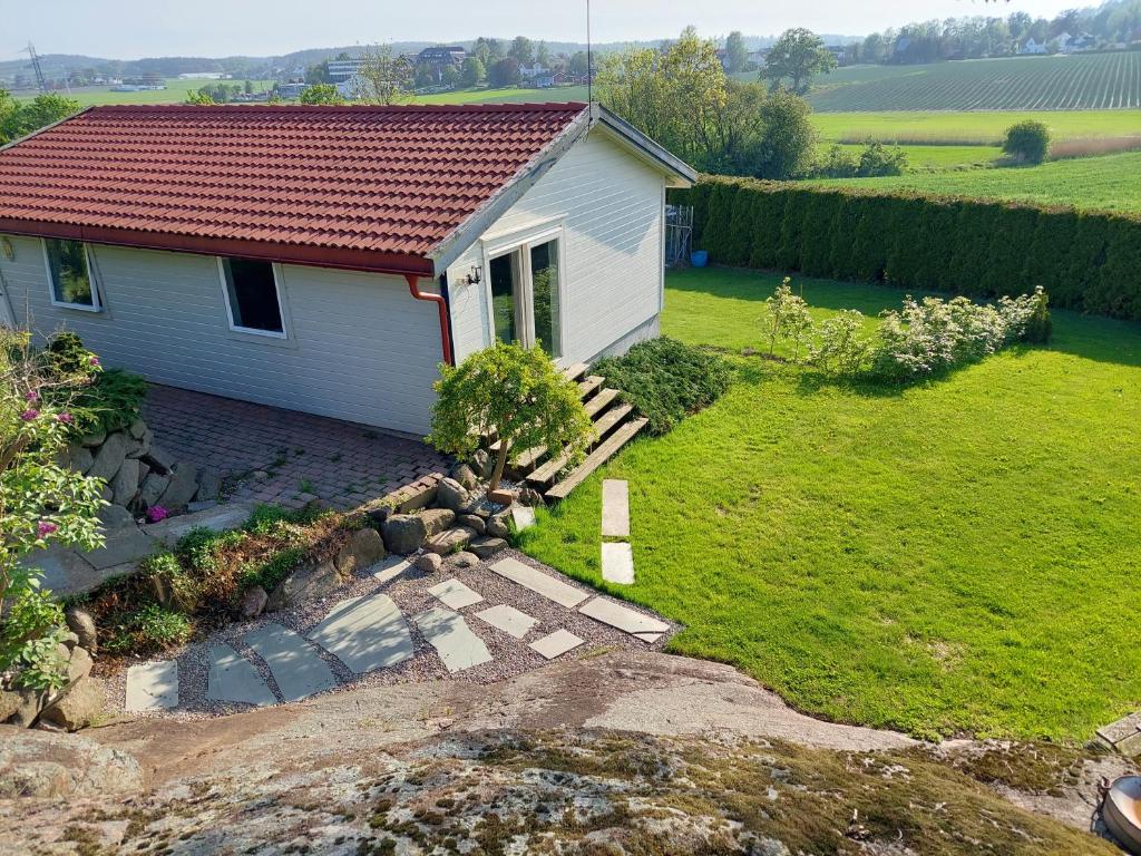 una pequeña casa blanca con techo rojo en Lille Øye Rest Aparment Nøtterøy, en Nøtterøy