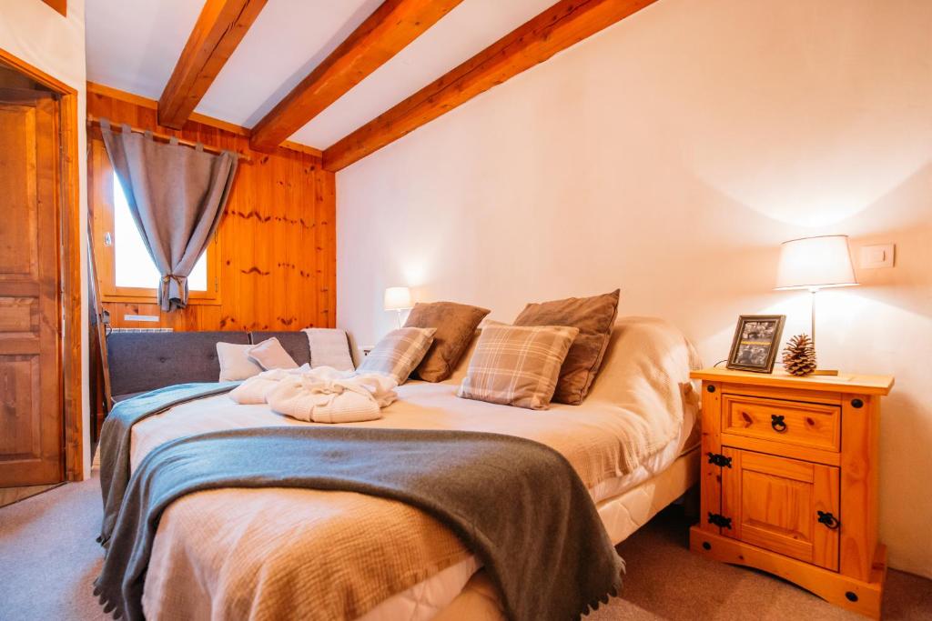 a bedroom with a bed and a night stand with a lamp at Chalet Perle in La Plagne Tarentaise