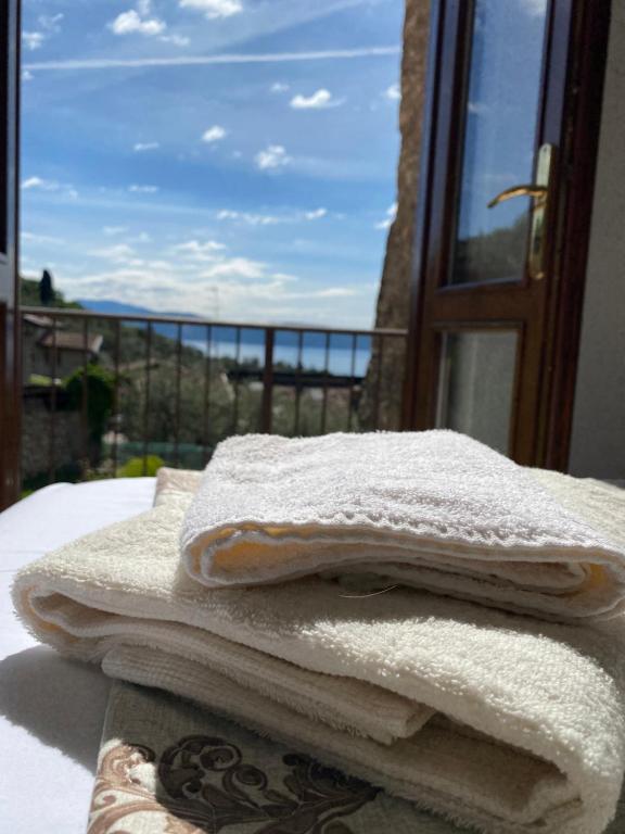 ein Haufen Handtücher auf einem Tisch neben einem Fenster in der Unterkunft AGORA' Home in Gardone Riviera