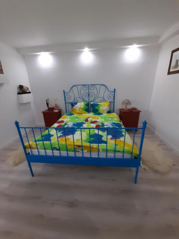 un letto blu con un piumone colorato in una stanza di Skyline Central Apartment a Timişoara