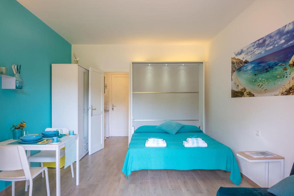a bedroom with a bed and a desk and a table at Appartamenti LE TRE API in Porto Azzurro