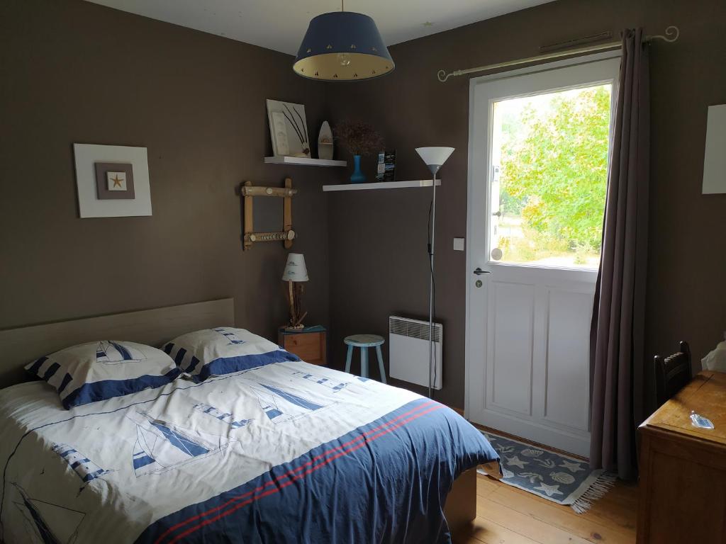 sypialnia z łóżkiem, oknem i drzwiami w obiekcie Villa Maryne w mieście Andernos-les-Bains