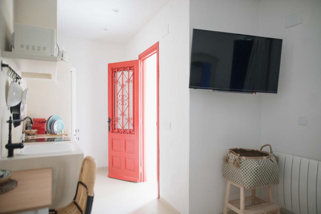 a red door with a television on a white wall at Quinta la Sal in Jávea