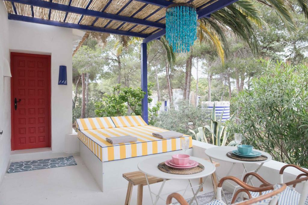 a patio with a couch and tables and a red door at Quinta la Sal in Jávea