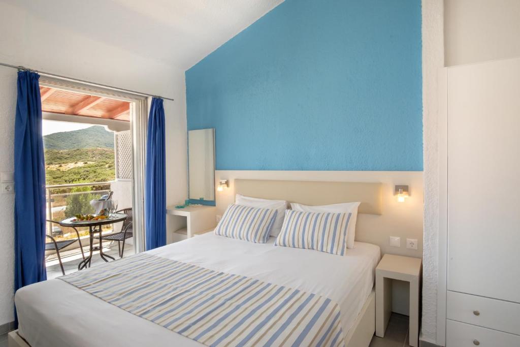 a bedroom with a bed and a large window at Blue Senses Apartments in Sarti