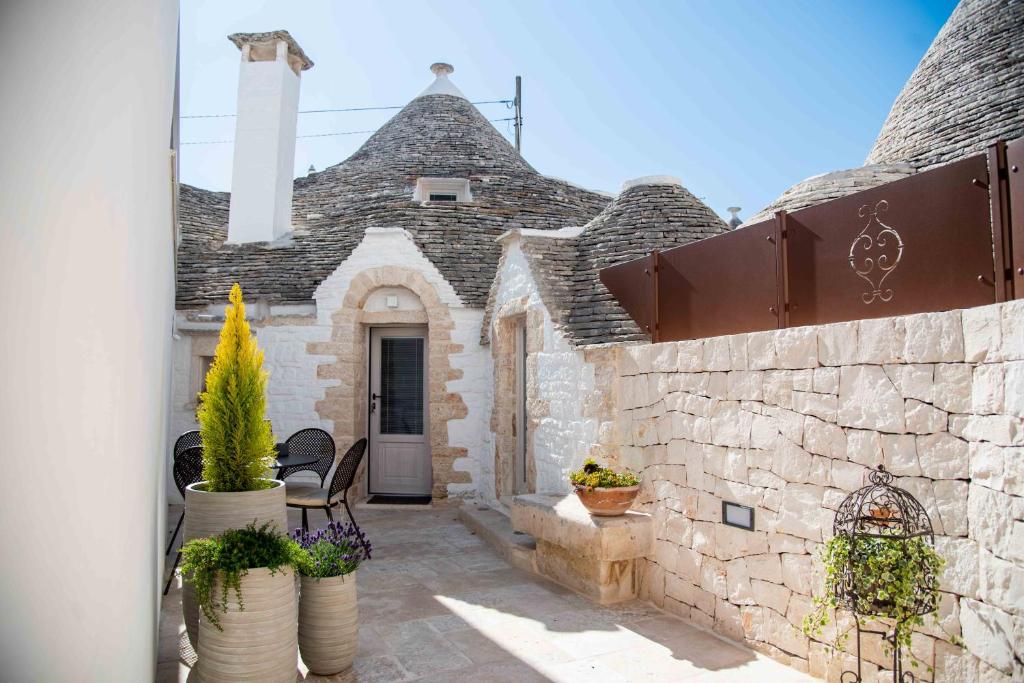 una casa con un edificio de piedra con macetas en Chiancole - Trulli Experience en Alberobello