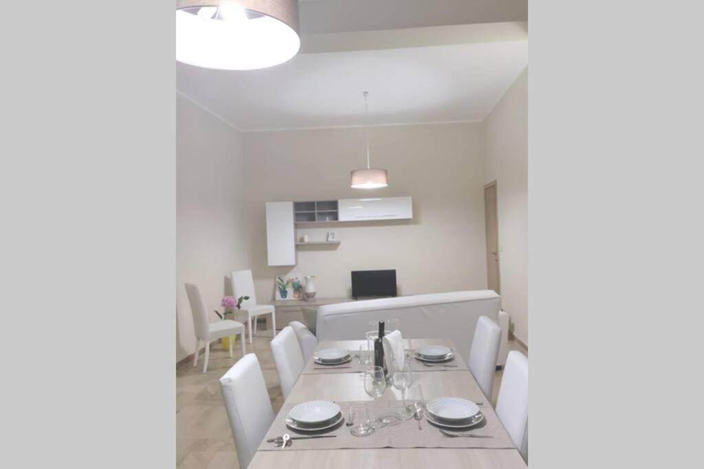 un comedor blanco con mesa y sillas blancas en Apartment Miriade, en Balestrate