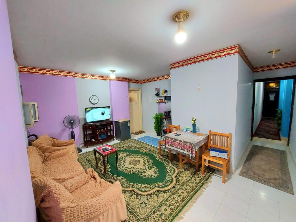 een woonkamer met een bank en een tv bij Caesar Studio Apartment in Alexandrië