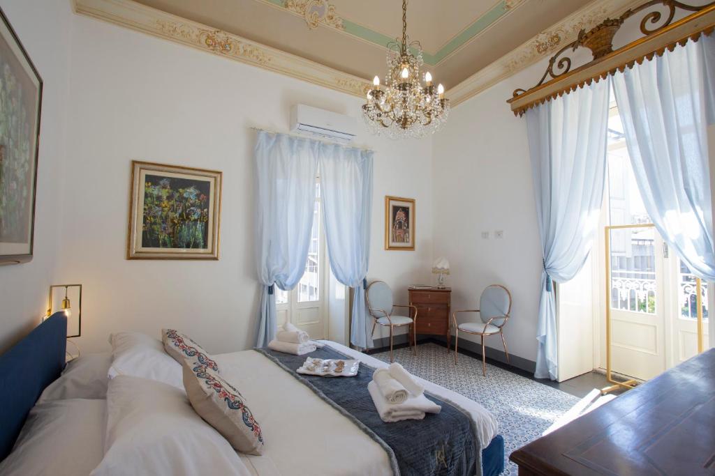 uma sala de estar com um sofá e um lustre em Palazzo d'Autore - Luxury Home - Ragusa Centro em Ragusa