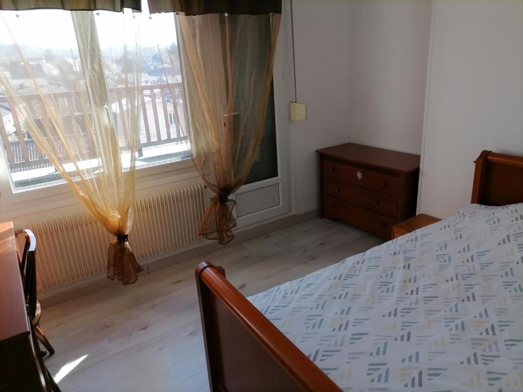 a bedroom with a bed and two windows at Gite Louvre Opale in Desvres