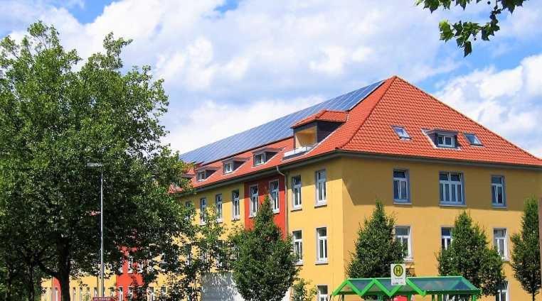 a large yellow and orange building with a red roof at Boardinghouse am Rosensee in Aschaffenburg