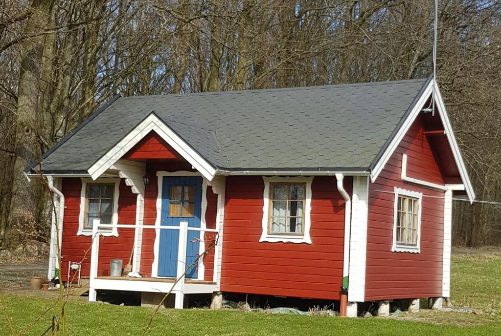 uma casa vermelha com um telhado preto em Lill Hagahus, Söderåsens Nationalpark em Kågeröd