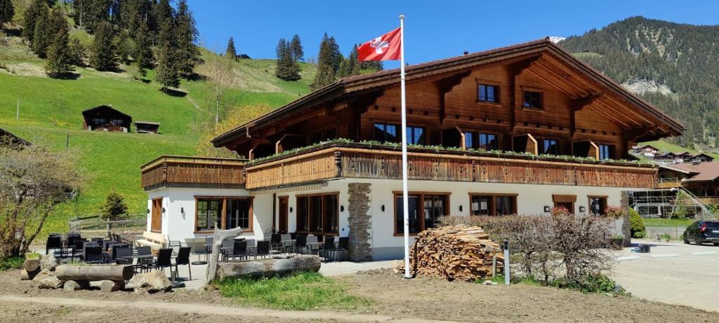 阿德爾博登的住宿－Bodehüttli，前面有吊旗的建筑