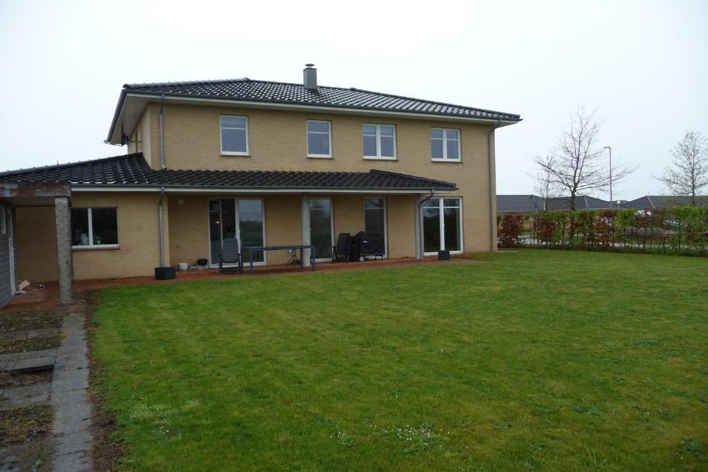 een huis met een grote tuin ervoor bij Værelse i Augustenborg i stor villa in Augustenborg