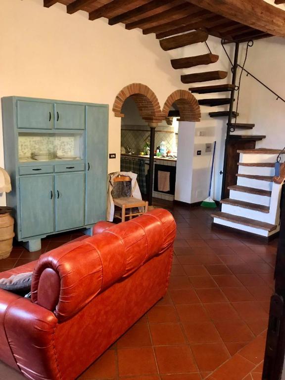 a living room with a leather couch and a staircase at Casa Vacanze Il Torchio in Piancastagnaio