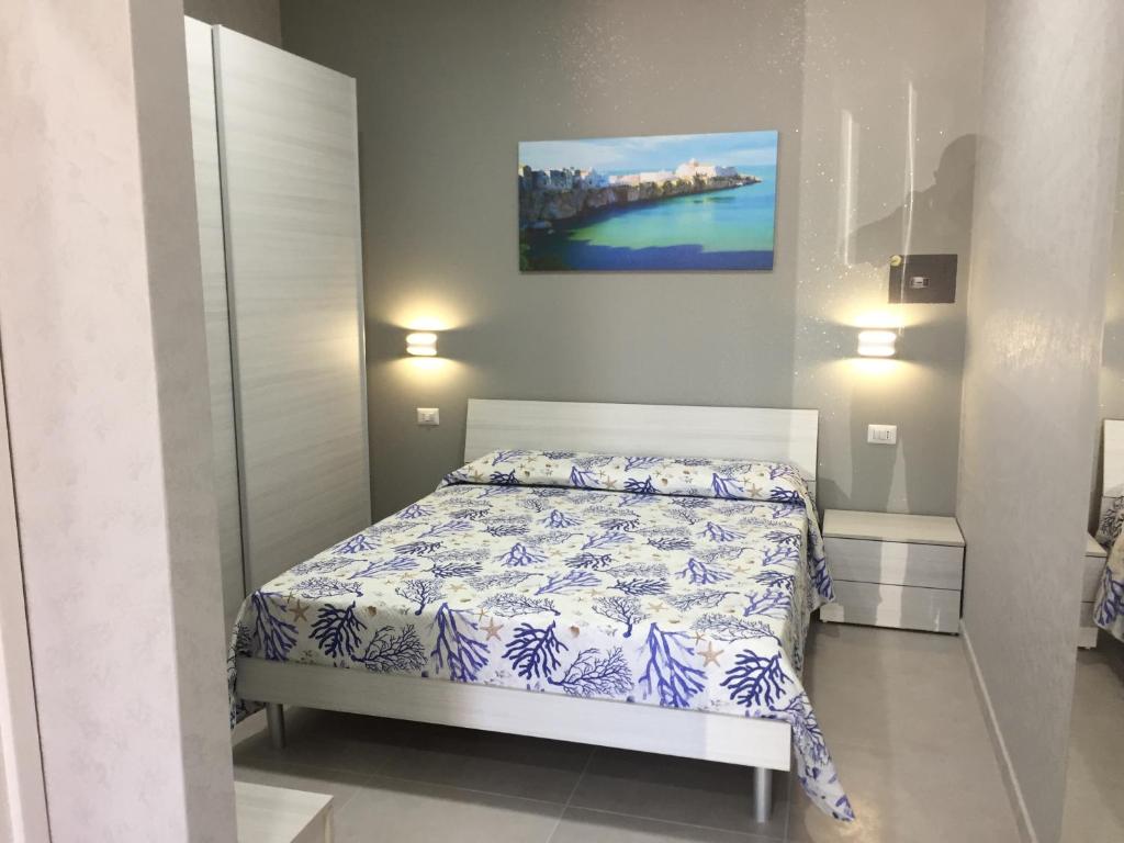 a bedroom with a bed and a painting on the wall at RICCIARDELLI HOLIDAY HOMES in paese di fronte al Mare in Vieste