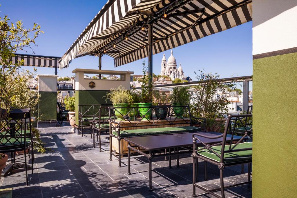 d'une terrasse avec des tables, des chaises et un parasol. dans l'établissement Hotel Rochechouart - Orso Hotels, à Paris