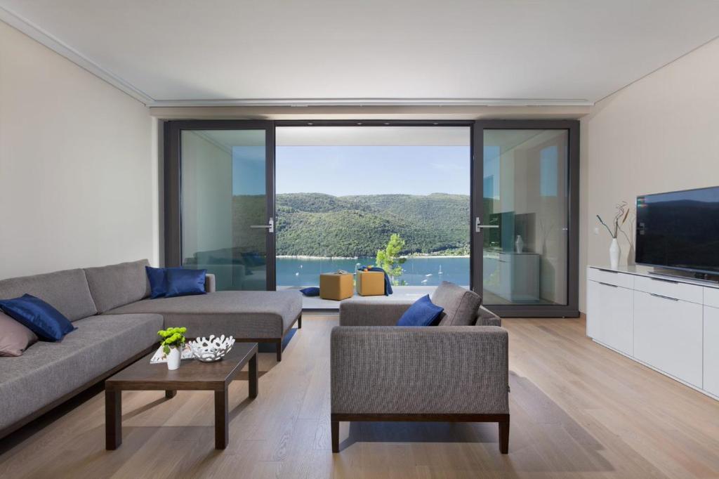 a living room with a couch and a tv at Park Hill Residences in Rabac