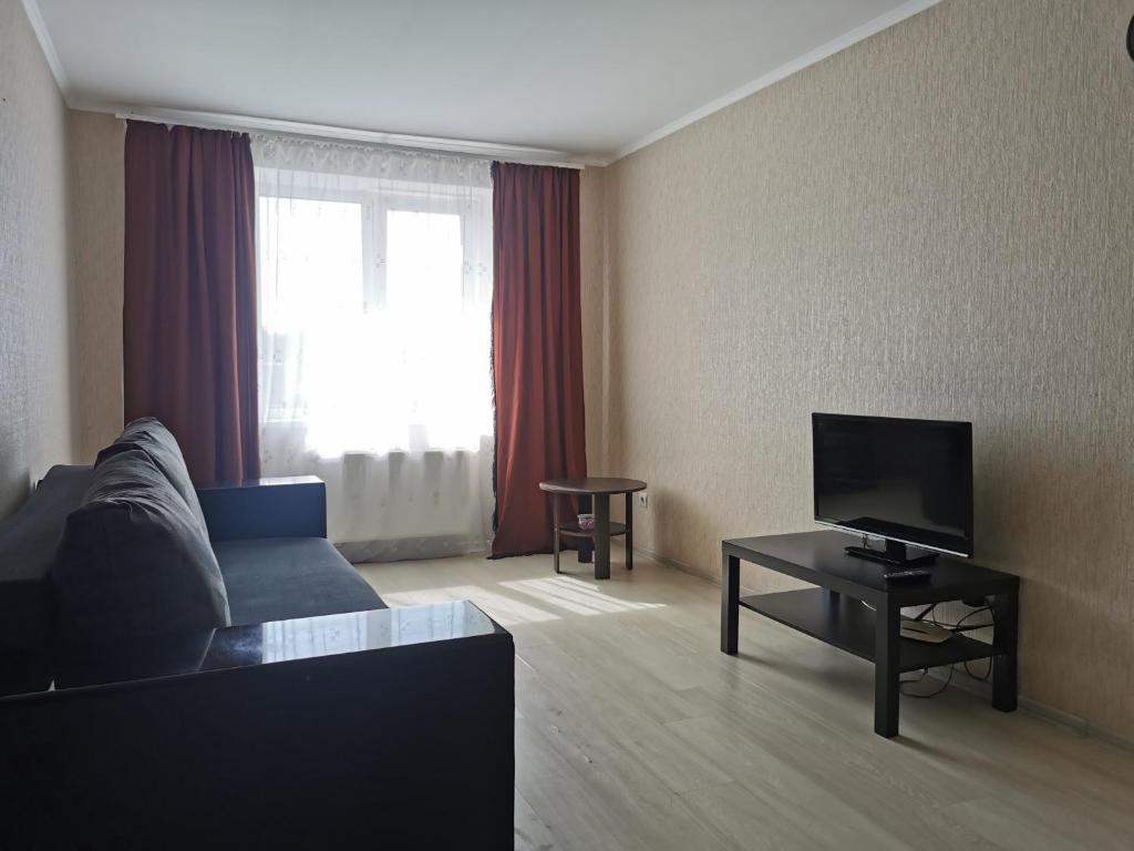 a living room with a couch and a tv at Kakadu apartments in Sumy