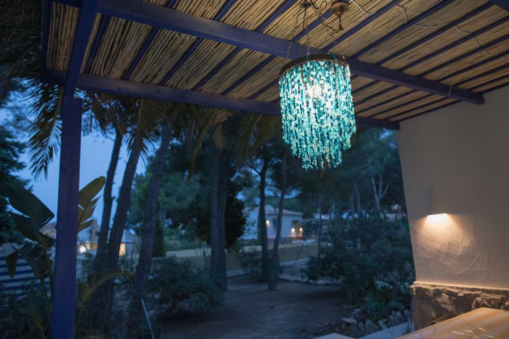 a chandelier hanging from a wooden pergola at Quinta la Sal in Jávea