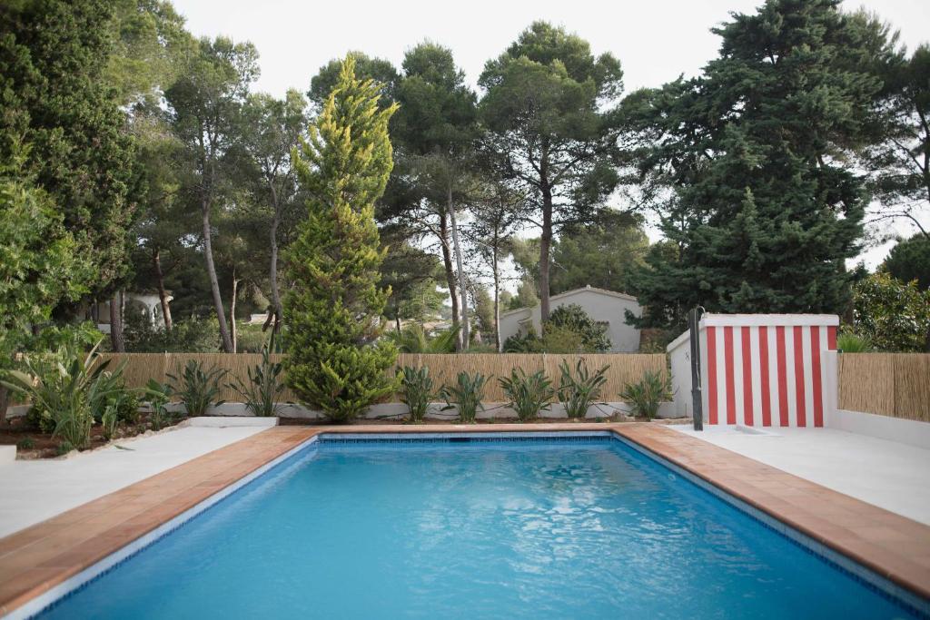 a swimming pool in a backyard with a fence and trees at Quinta la Sal in Jávea