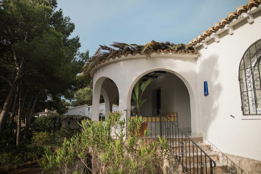a white house with an archway and trees at Quinta la Sal in Jávea