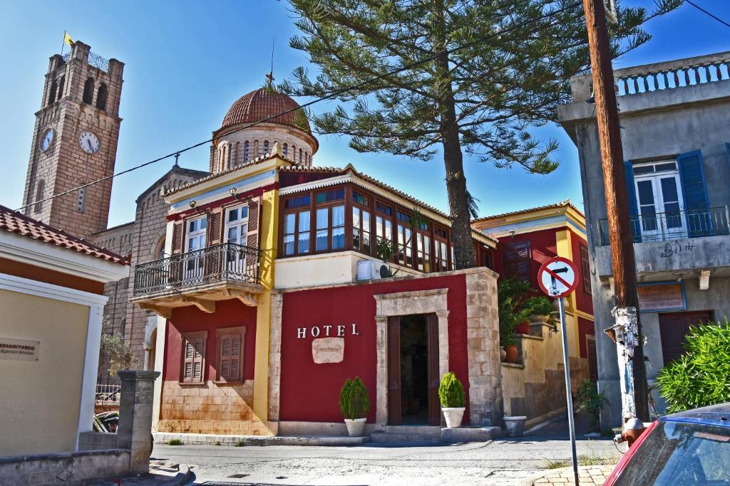 a hotel with a clock tower and a red building at Aeginitikon Arhontikon Stylish Boutique Hotel in Egina