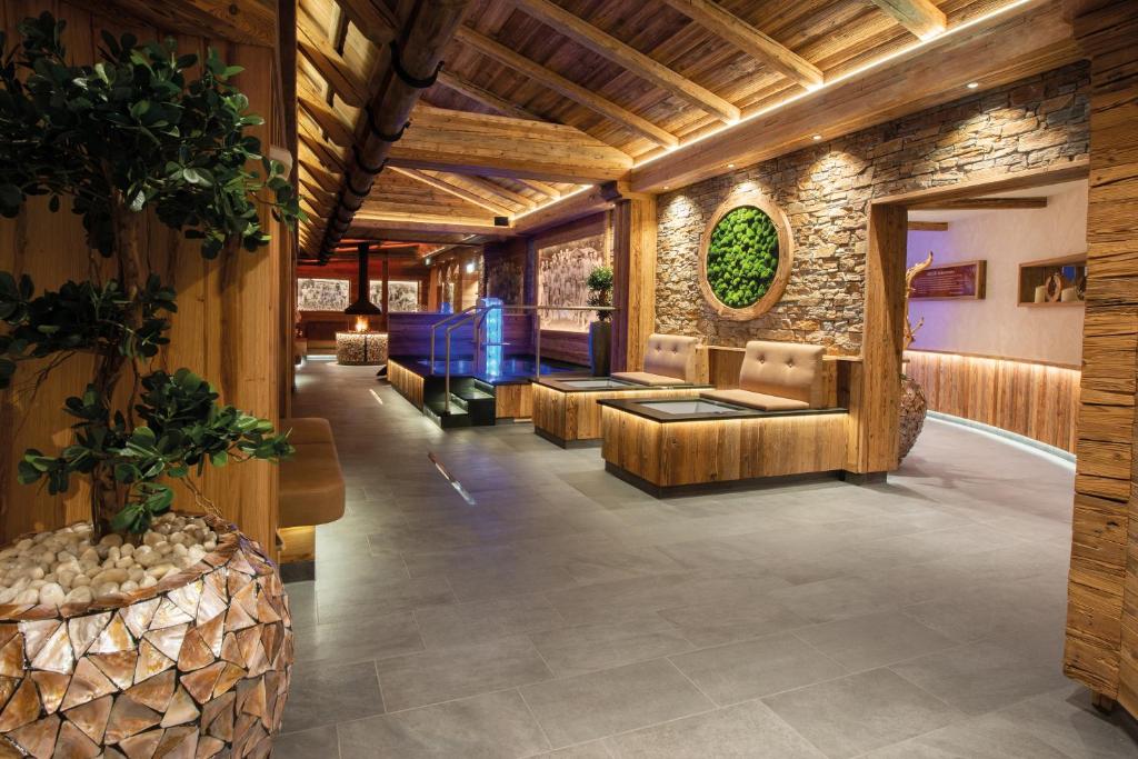 a lobby with couches and a stone wall at Wellness-Hotel ADLER in Bad Wörishofen