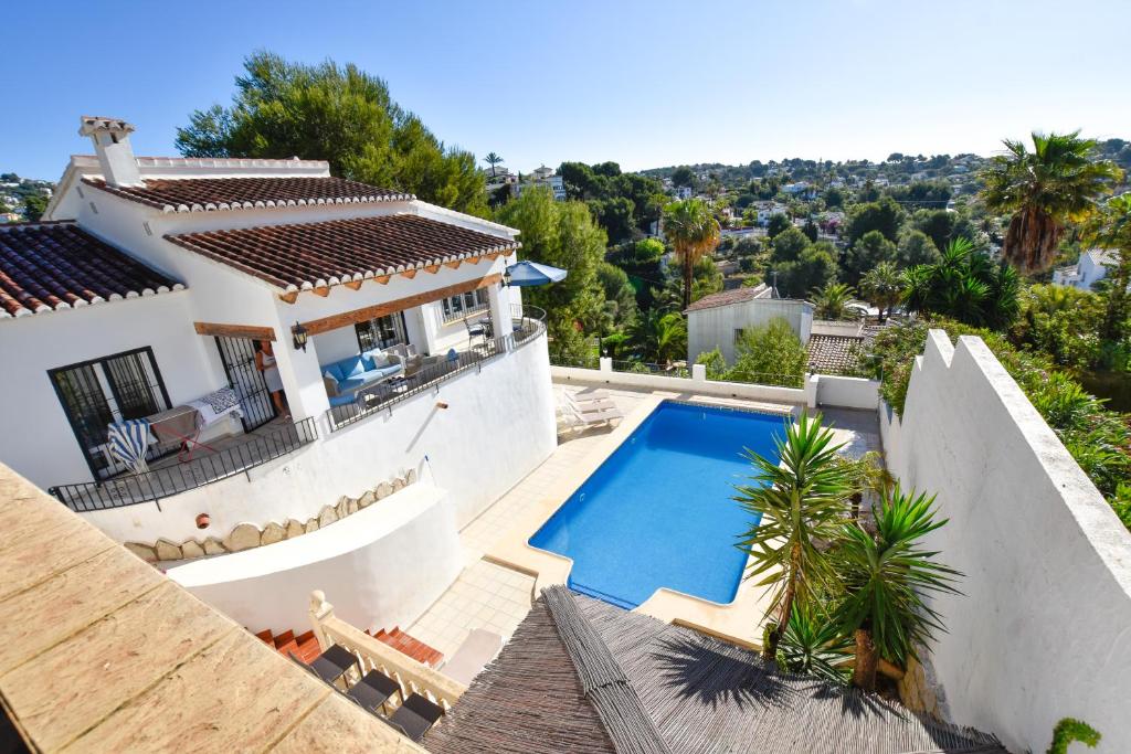 a villa with a swimming pool in front of a house at Villa La Buena Vida in Benissa