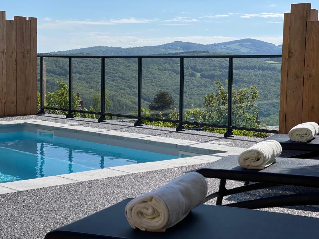 a swimming pool with a view of the mountains at Logis Au Vieux Morvan in Château-Chinon