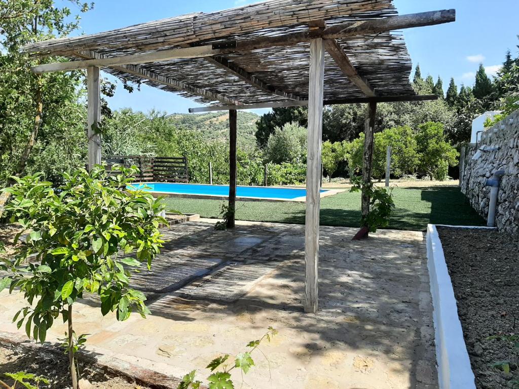 pérgola de madera con piscina en un patio en Vivienda Rural Maestro Herrador en Ubrique